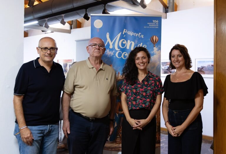 Cuatro personas posan junto al cartel del 10.º Festival de Narración Oral Paiporta Món de Contes en el Museu de la Rajoleria